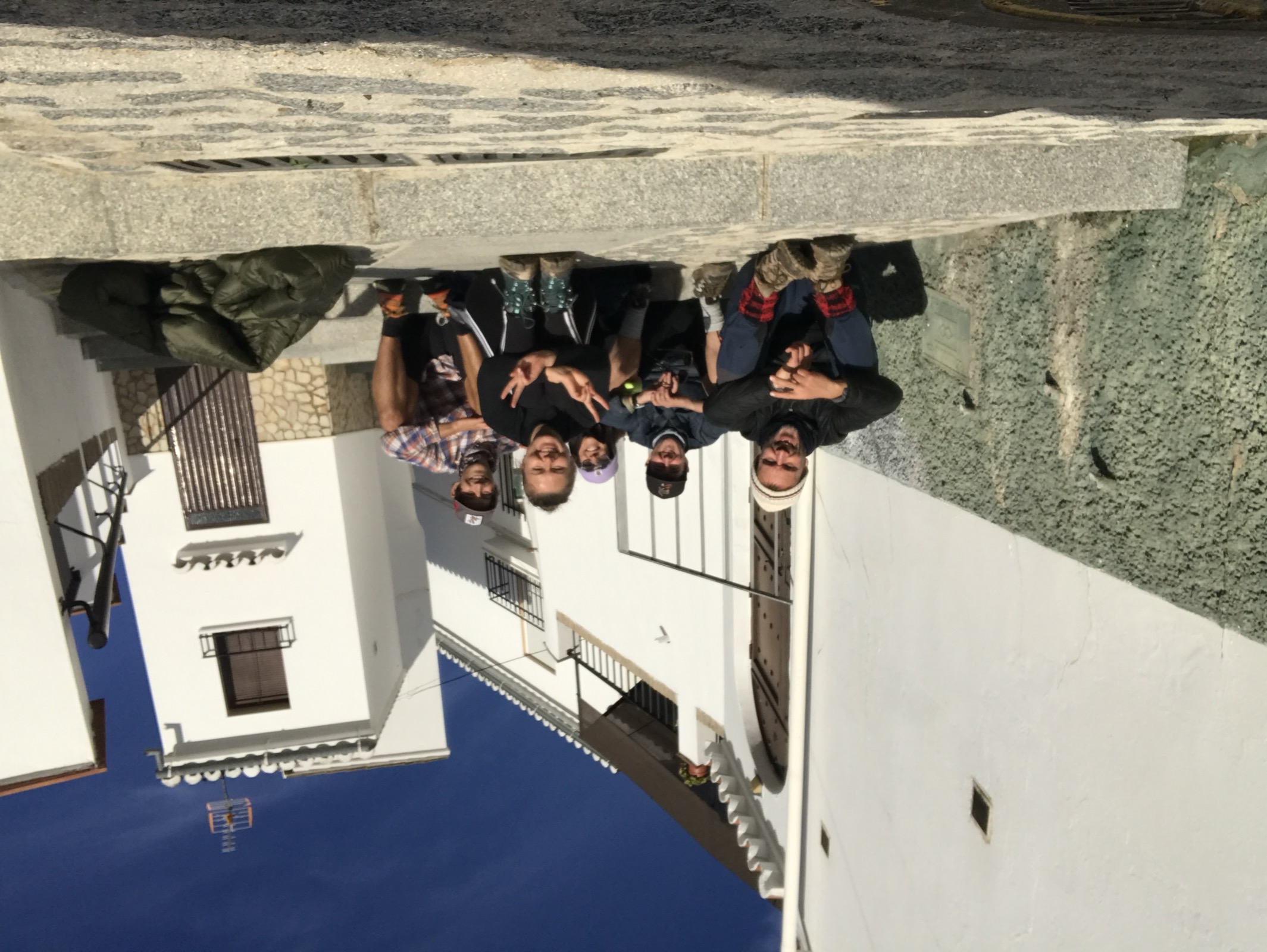 Friends gathered on the steps of a white Andalusian pueblo